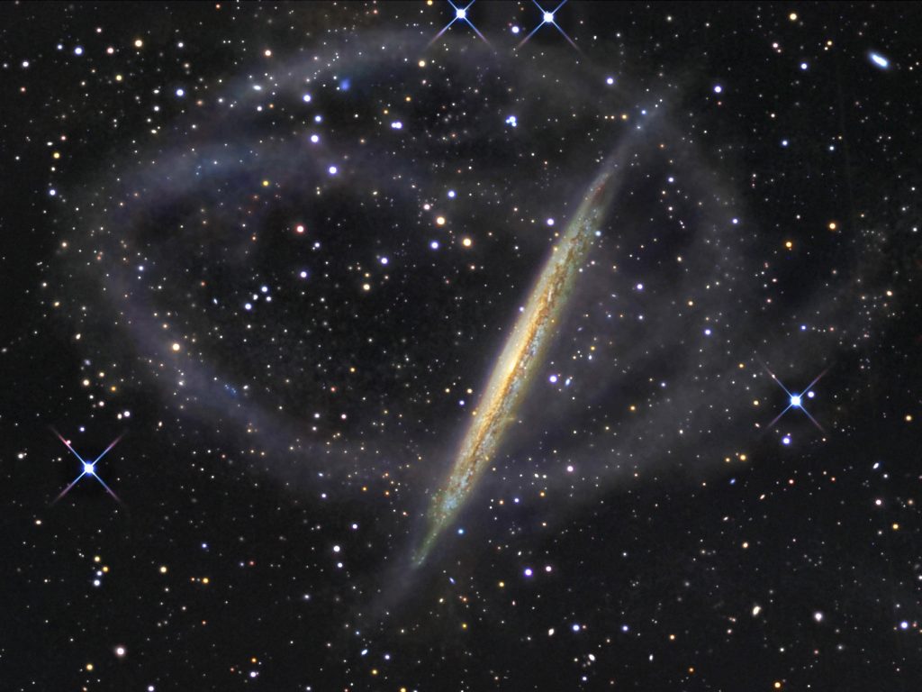 NGC 5907 ze sznurem gwiazd wyrywanych z macierzystej galaktyki. Żródło - APOD (Astronomy Picture of the Day), 2008.